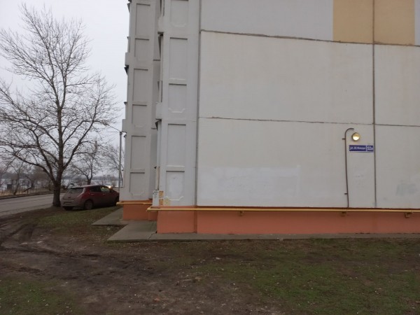 Житель Воронежа под балконом, портя газон, заряжает свой экологичный электромобиль